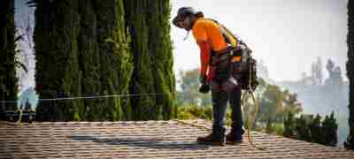 LASG technician working on a roof